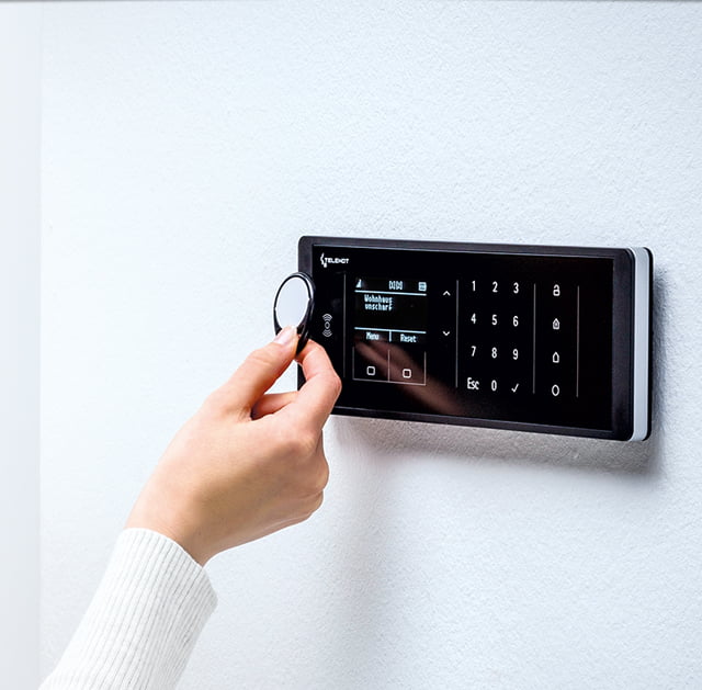 Foto einer Frau die einen RFID-Key an ein Display hält